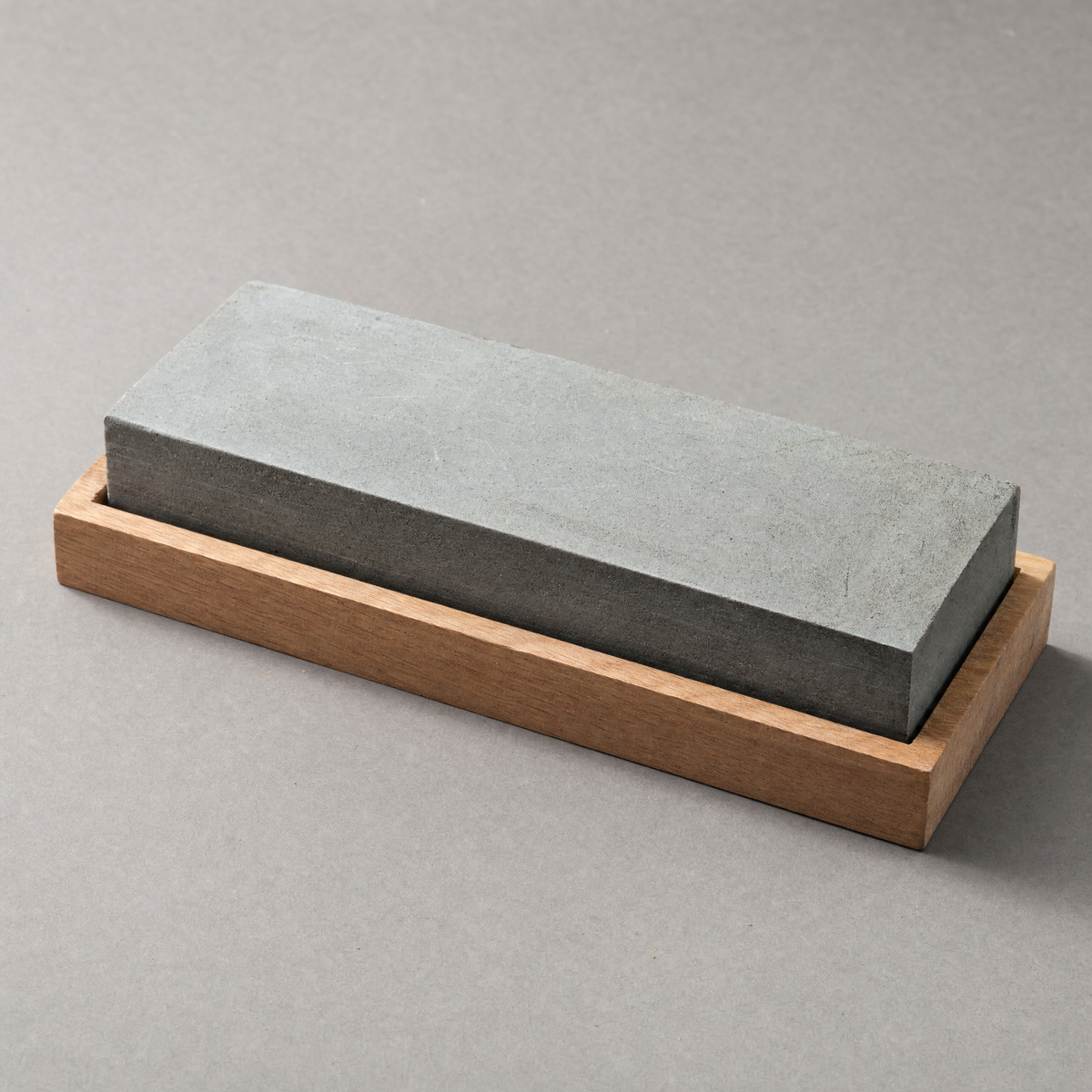 The Whetstone 1000/6000: a two-sided grey water stone seated in a plain hardwood cradle.