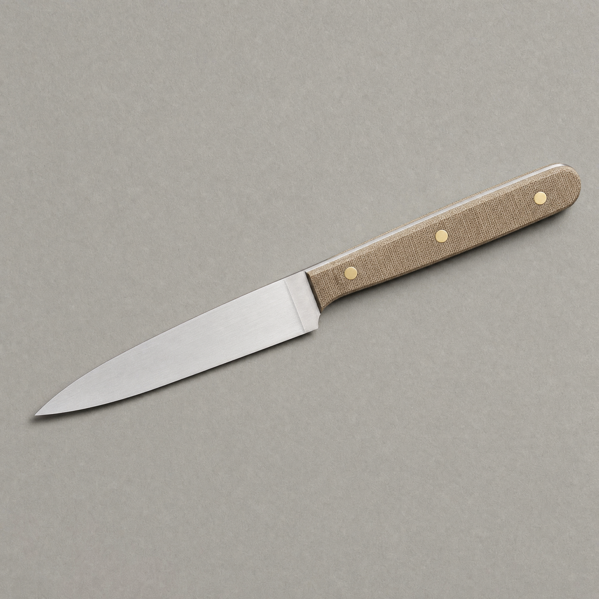 The Prep 130 seen from above: a narrow 130 mm satin stainless blade with a natural linen micarta handle on three brass pins.